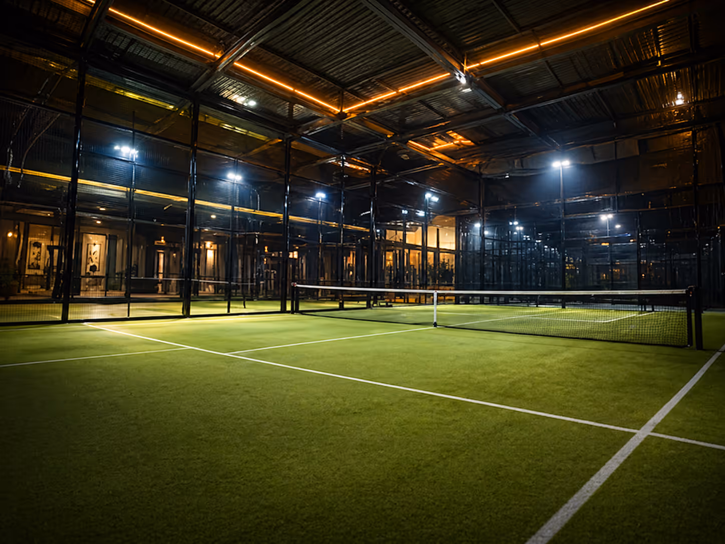 Floodlit indoor turf court at night