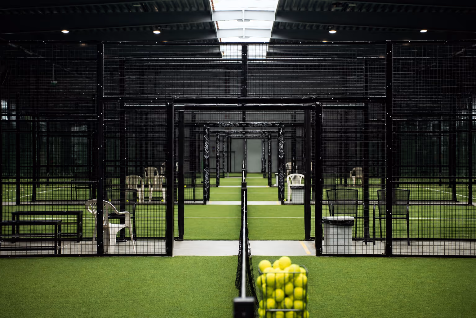 Rows of caged indoor turf courts